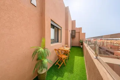 a balcony with a table and chairs on a building at Chic 2BR apartment wifi balcon in Marrakech