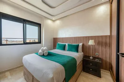 a bedroom with a large bed and a window at Chic 2BR apartment wifi balcon in Marrakech