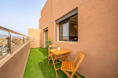 a table and chairs on the balcony of a building at Chic 2BR apartment wifi balcon in Marrakech