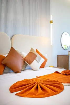 a bed with an orange blanket and pillows on it at Villa Luxe Neuve , Piscine XXL , Sans vis-à-vis in Marrakech