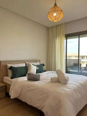 a bedroom with a large bed with a laptop on it at Appartement with a view on the pool in Marrakech
