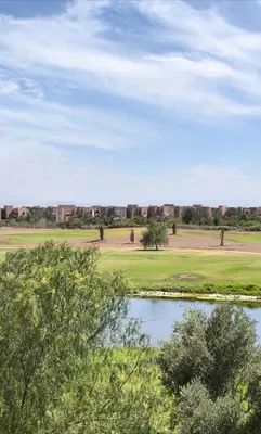 a view of a golf course with a pond at Appartement with a view on the pool in Marrakech
