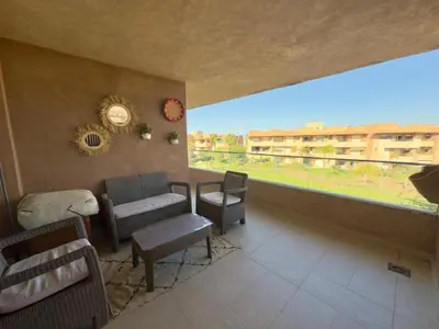 a living room with chairs and a large window at Appartement with a view on the pool in Marrakech