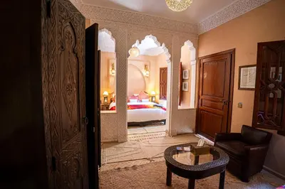 a room with a bedroom with a bed and a table at Riad Jamaique - Marrakech in Marrakech
