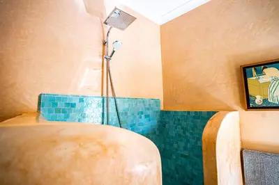 a bathroom with a shower with blue tiles at Riad Jamaique - Marrakech in Marrakech