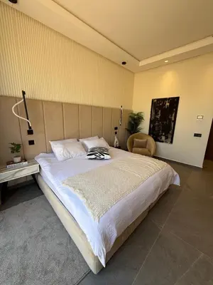 a bedroom with a large bed and a chair at Villa ALIYAH in Marrakech