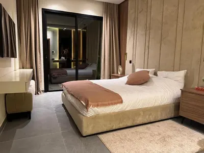 a bedroom with a large bed and a living room at Villa ALIYAH in Marrakech