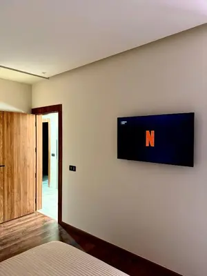 a television on the wall of a bedroom at Elegant & Cozy Stay in Center in Marrakech