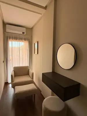 a living room with a chair and a mirror at Elegant & Cozy Stay in Center in Marrakech