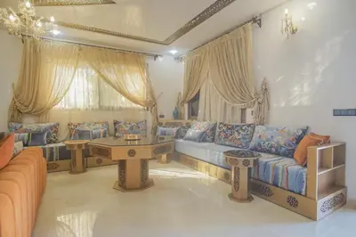 a living room with couches and a table at Villa B with a private pool in Oulad Ikhia