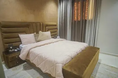 a bedroom with a large bed with a wooden headboard at Villa B with a private pool in Oulad Ikhia