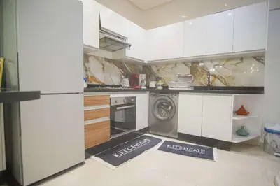 a kitchen with white cabinets and a washer and dryer at Villa B with a private pool in Oulad Ikhia