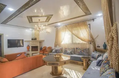a living room with orange furniture and a fireplace at Villa B with a private pool in Oulad Ikhia