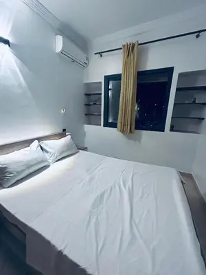 a white bed in a room with a window at Appartement 2 Chambres Confortable à Jnane Awrad Calme & Sécurité in Marrakech