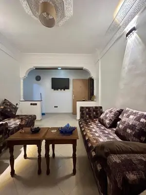 a living room with a couch and a table at Appartement 2 Chambres Confortable à Jnane Awrad Calme & Sécurité in Marrakech