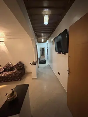 a living room with a couch and a flat screen tv at Appartement 2 Chambres Confortable à Jnane Awrad Calme & Sécurité in Marrakech