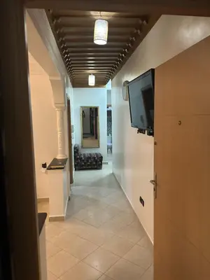 a hallway with a flat screen tv on a wall at Appartement 2 Chambres Confortable à Jnane Awrad Calme & Sécurité in Marrakech