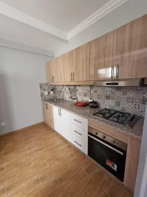 a kitchen with wooden cabinets and a stove top oven at Modern Fully equipped 2 rooms apartment in Marrakech
