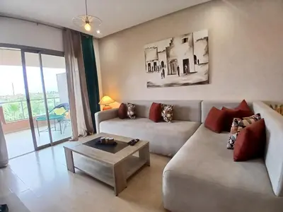 a living room with a couch and a coffee table at Appartement Prestigia Marrakech Maroc Golf Piscine in Marrakech