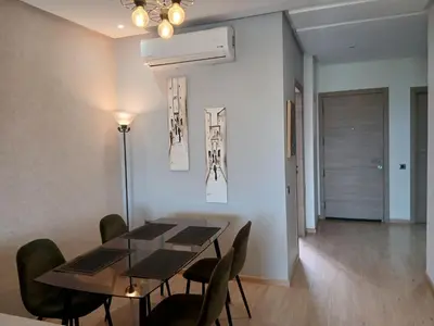 a dining room with a table and chairs at Appartement Prestigia Marrakech Maroc Golf Piscine in Marrakech