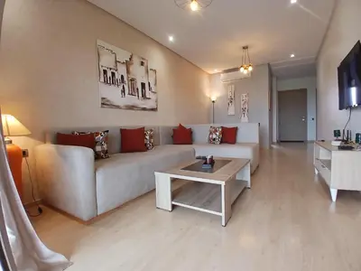 a living room with a couch and a table at Appartement Prestigia Marrakech Maroc Golf Piscine in Marrakech