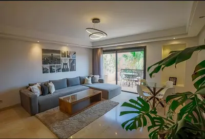 a living room with a blue couch and a table at Generosa studio in Marrakech