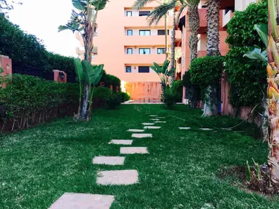 a path in the grass in front of a building at Generosa studio in Marrakech