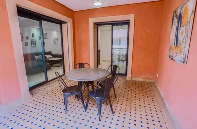 a table and chairs in a room with orange walls at Generosa 22 in Marrakech