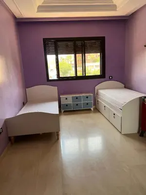 two beds in a room with purple walls at GUELIZ 2 chambres 1 terrasse proche majorelle in Marrakech