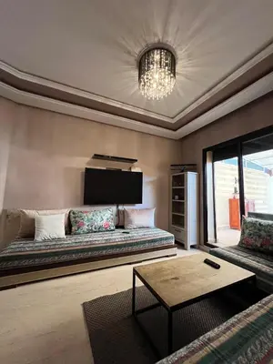 a living room with a couch and a table at GUELIZ 2 chambres 1 terrasse proche majorelle in Marrakech