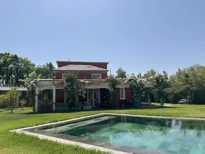 a house with a swimming pool in front of it at Yasira in Marrakech