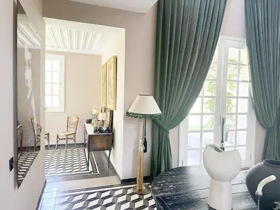 a living room with green curtains and a floor lamp at Yasira in Marrakech
