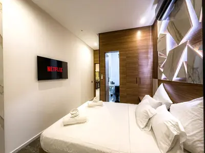 a bedroom with a bed with a tv on the wall at Séjour chic en ville Jacuzzi privé et Wi-Fi gratuit in Marrakech