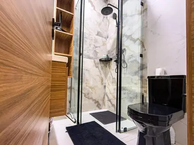a bathroom with a black toilet and a shower at Séjour chic en ville Jacuzzi privé et Wi-Fi gratuit in Marrakech