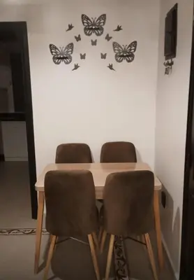 a dining room table with butterflies on the wall at Apartement Mabrouka in Marrakech