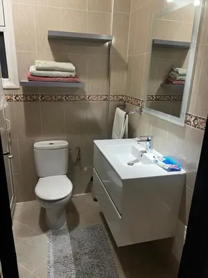 a bathroom with a white toilet and a sink at Apartement Mabrouka in Marrakech