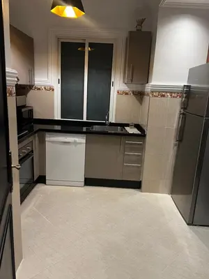 a kitchen with black and white counters and appliances at Apartement Mabrouka in Marrakech