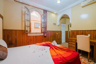 a bedroom with a bed and a desk at Riad Mazouz102 Médina in Marrakech