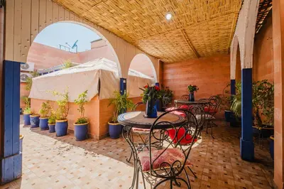 a patio with tables and chairs and potted plants at Riad Mazouz102 Médina in Marrakech
