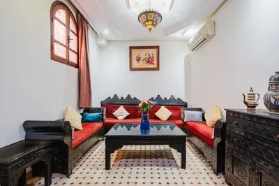 a living room with a red couch and a table at Riad Mazouz102 Médina in Marrakech