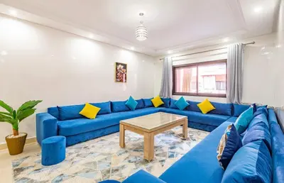 a blue couch in a living room with a table at AliZ Appartement 2 chambres avec piscine, Majorelle in Marrakech