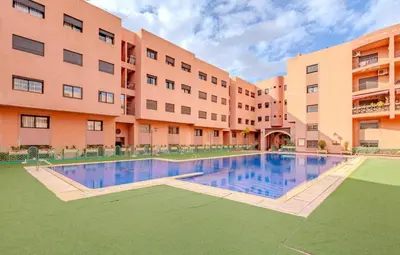 an apartment building with a swimming pool in front of a building at AliZ Appartement 2 chambres avec piscine, Majorelle in Marrakech
