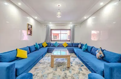 a living room with a blue couch and a table at AliZ Appartement 2 chambres avec piscine, Majorelle in Marrakech