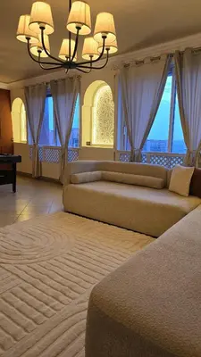 a large living room with two beds and a chandelier at Entire Luxury Duplex Appart 3Bedroom 2Living Rooms in Top Center in Marrakech