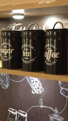 a shelf with three black containers of coffee on it at Entire Luxury Duplex Appart 3Bedroom 2Living Rooms in Top Center in Marrakech
