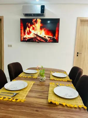 a table with chairs and plates and a fire at Appartement Gueliz in Marrakech