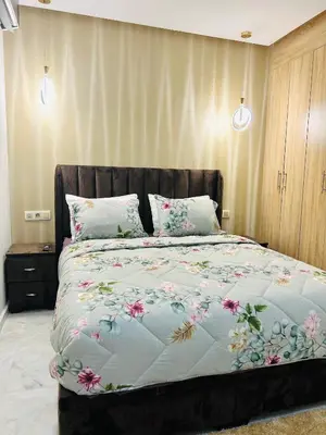 a bedroom with a large bed with flowers on it at Appartement Gueliz in Marrakech