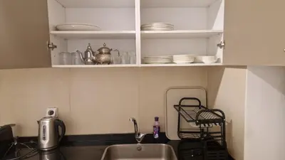 a kitchen with a sink and white cabinets with dishes at Noria Isli Dar Noor in Marrakech