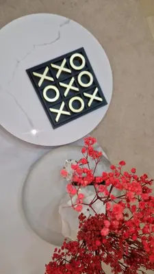 a white table with a vase with red flowers in it at Noria Isli Dar Noor in Marrakech