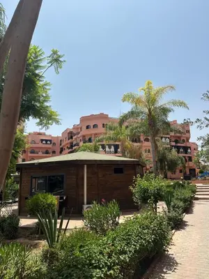 a small building in front of a large building at Apparemment première village in Marrakech